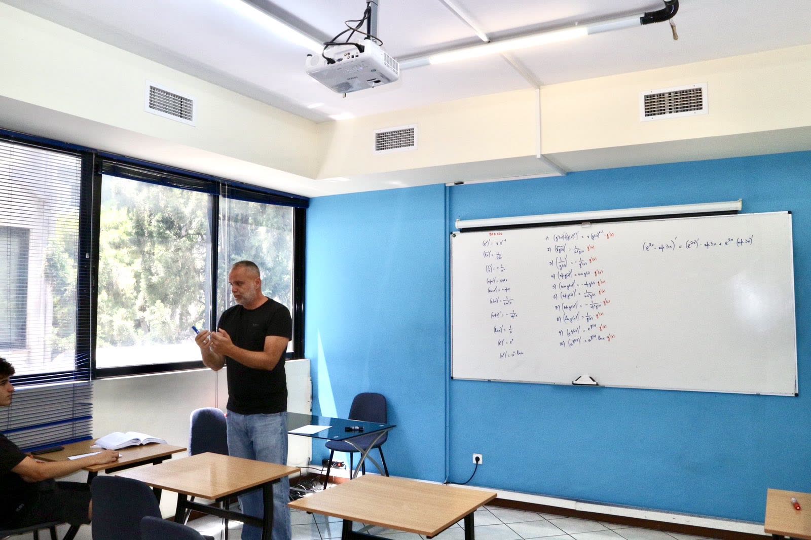 Καθηγητής λύνει ασκήσεις στον πίνακα, στο εργαστήριο